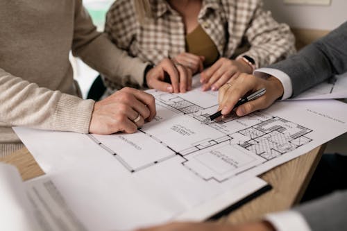 Free Man Showing a Blueprint to a Couple Stock Photo