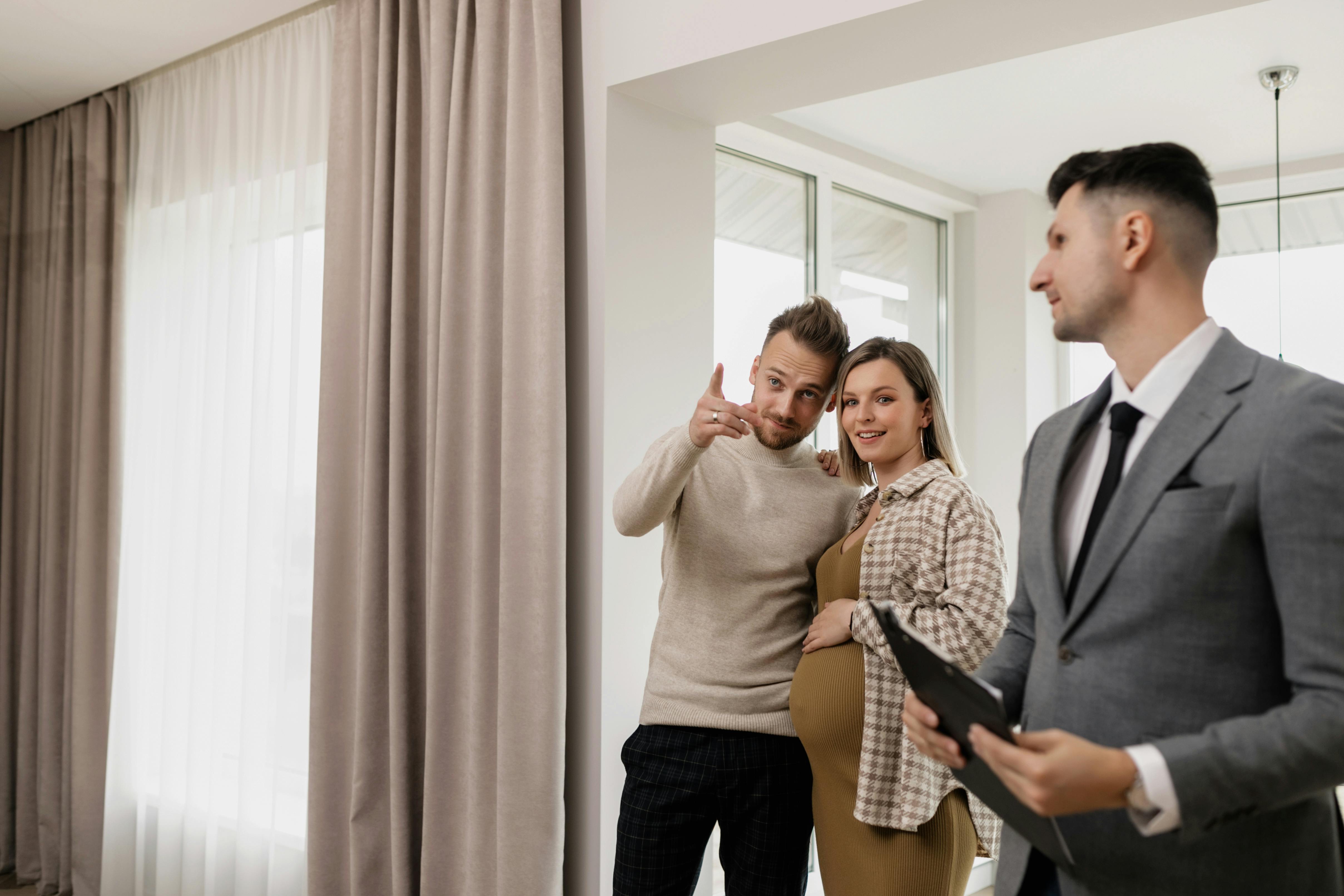 man standing beside pregnant woman and pointing at something