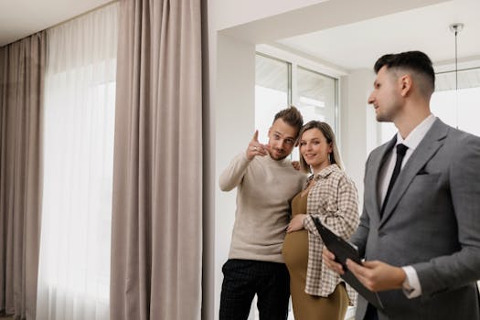 Expectant couple excitedly tours new home with real estate agent.