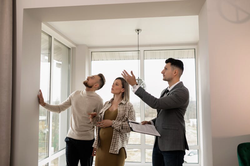 Young couple inspecting a modern apartment with a real estate agent during a property viewing