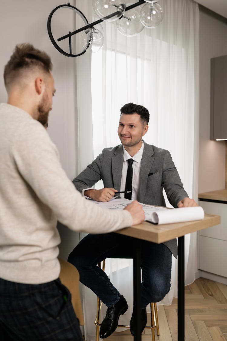 A Real Estate Agent Showing A Client Floor Plans