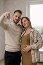 A joyful couple celebrating buying their new home, holding keys.