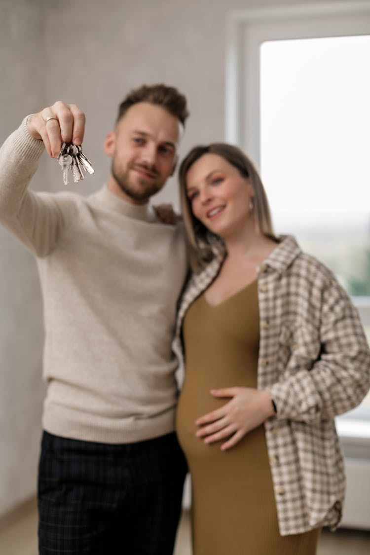 Man Holding Keys Beside A Pregnant Woman