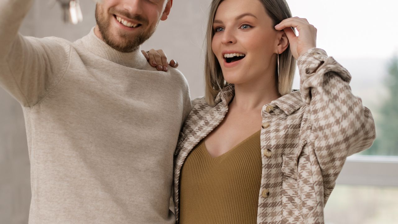 Sustainable low income homeownership Couple holding house keys after completing an affordable home purchase