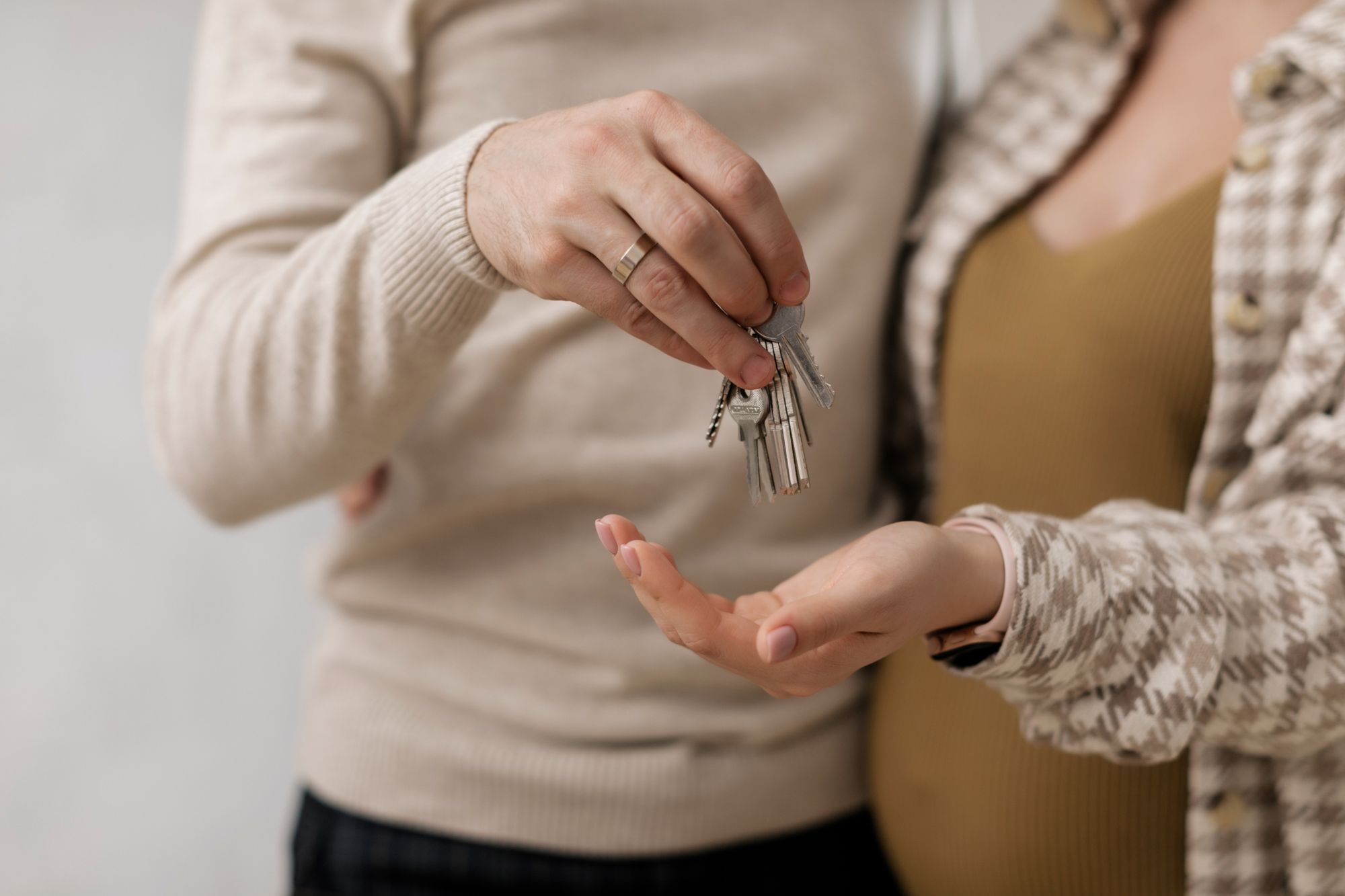 A couple holding a set of keys to a newly purchased home