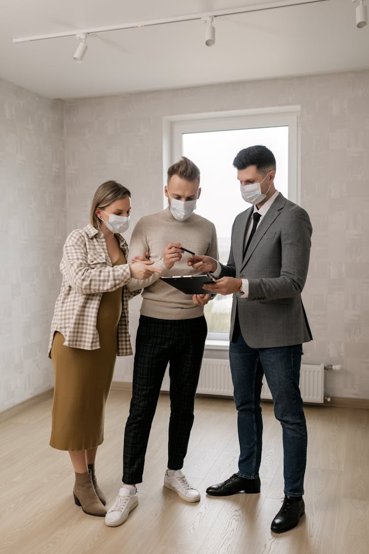 
A Couple With A Realtor Looking At A Document