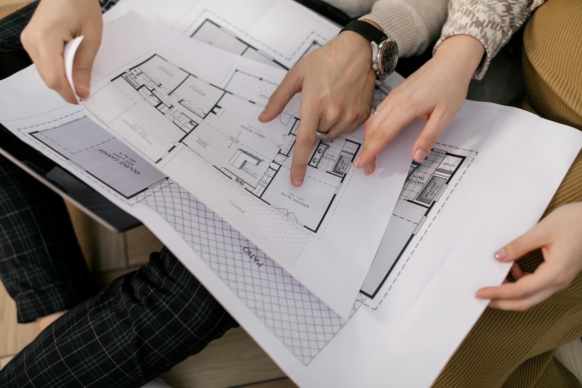 Two people examining architectural blueprints, focusing on project details.