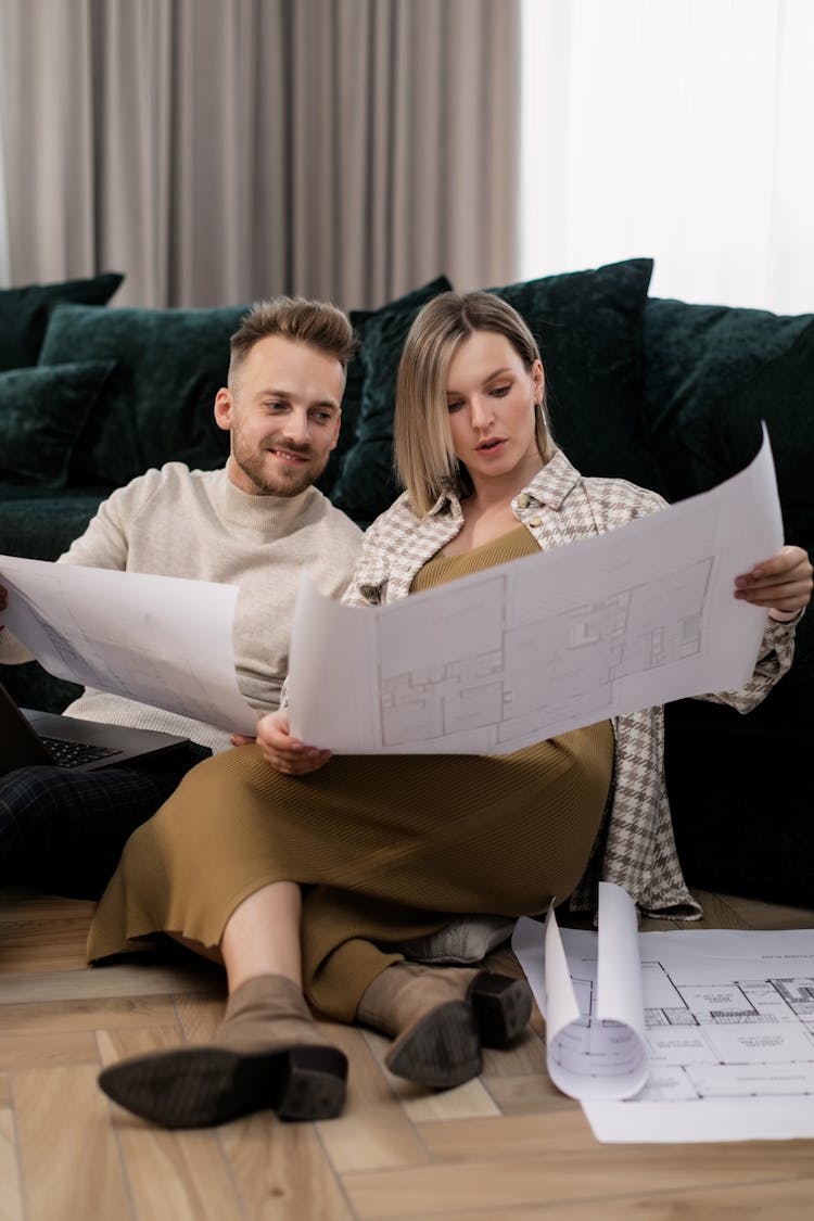 A Couple Looking At Blueprints