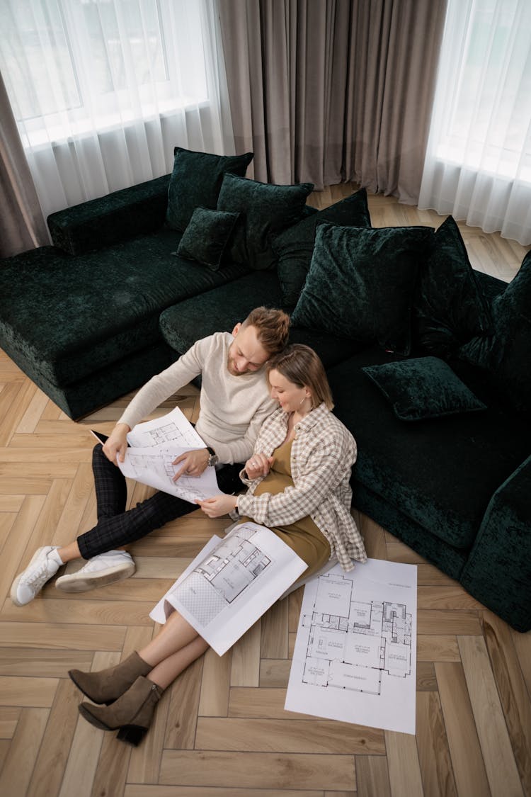 A Couple Looking At A Blueprint