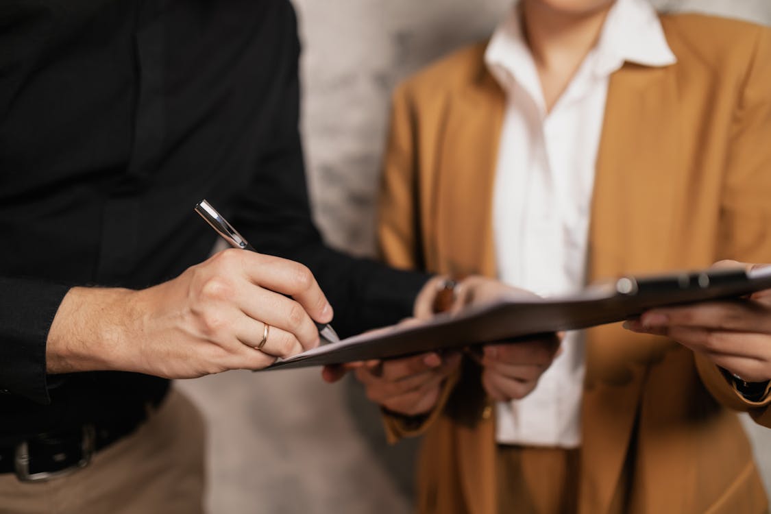 Free A Person Signing a Document Stock Photo