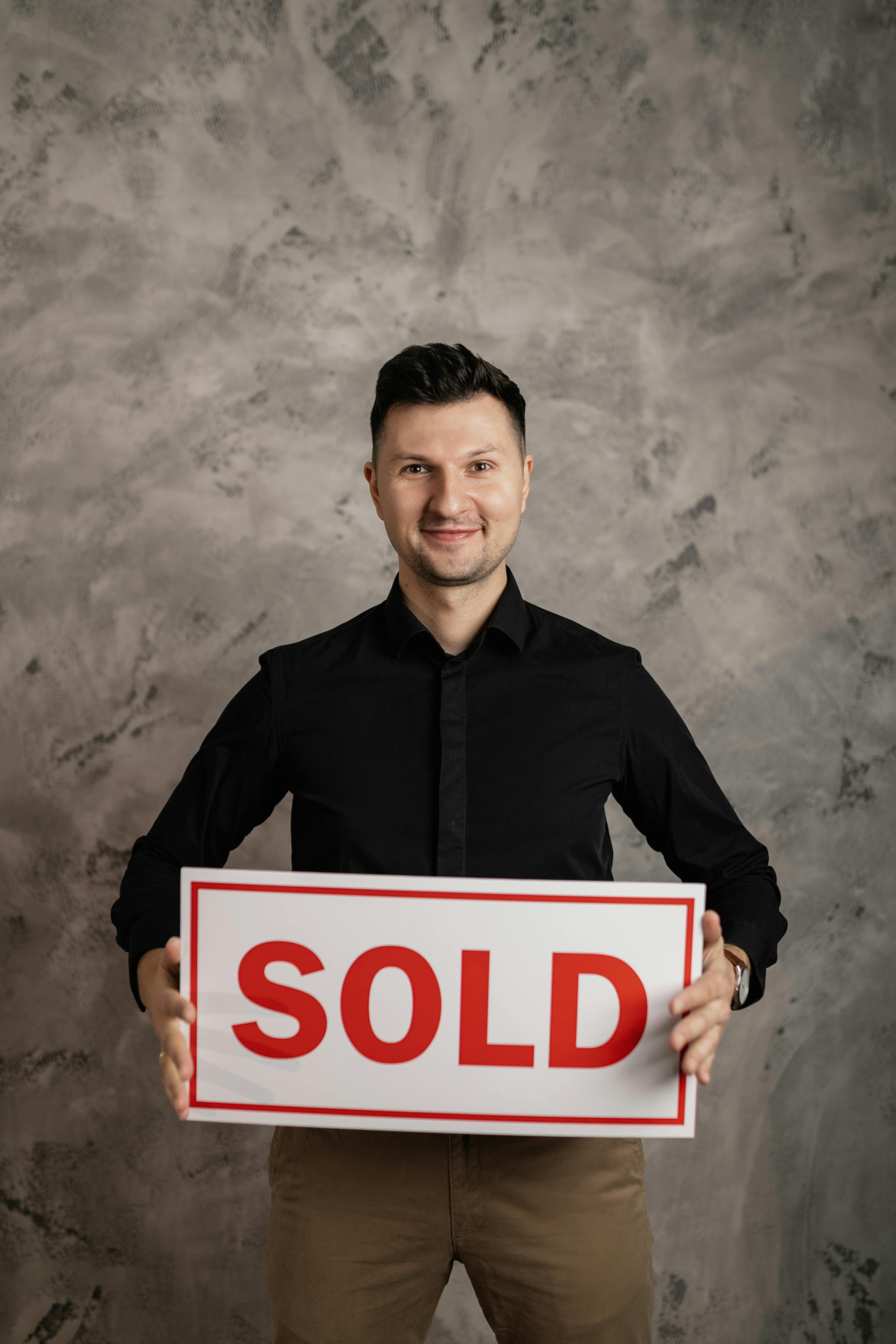 a man in a black long sleeved shirt holding a sign