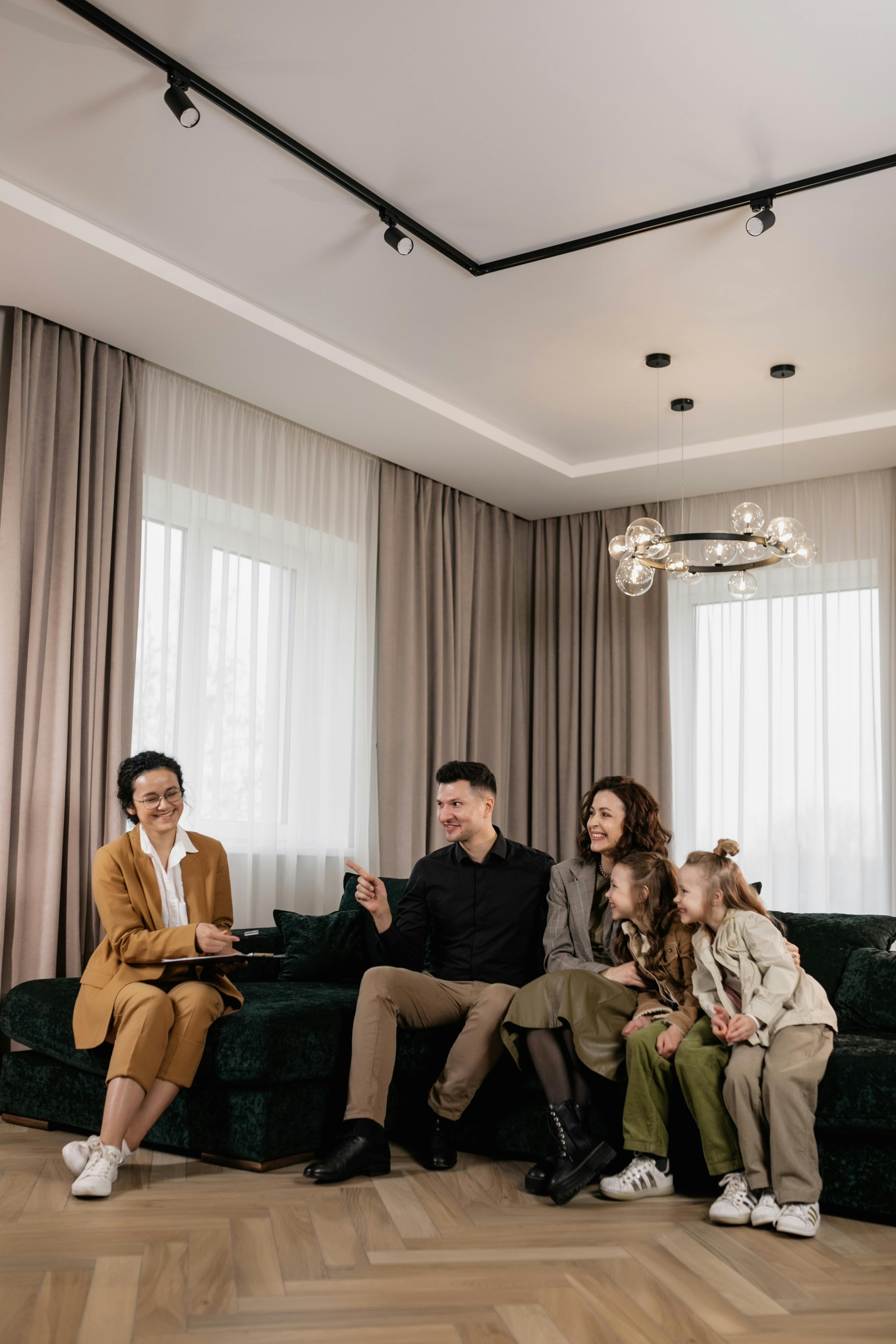a family sitting on a couch with a real estate agent