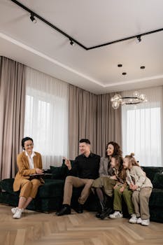 Family discusses new home purchase with real estate agent in a cozy living room setting.