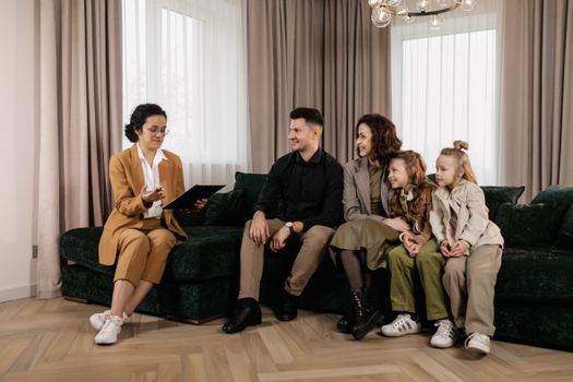 Family discussing home purchase options with real estate agent indoors.
