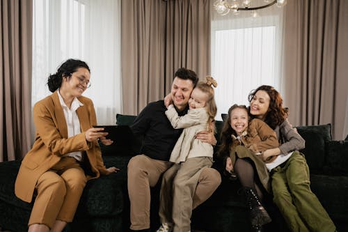 Free 
A Family Sitting on a Couch with a Real Estate Agent Stock Photo