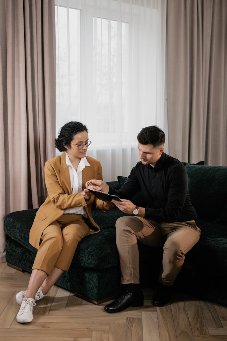 
A Realtor Showing A Document To A Client