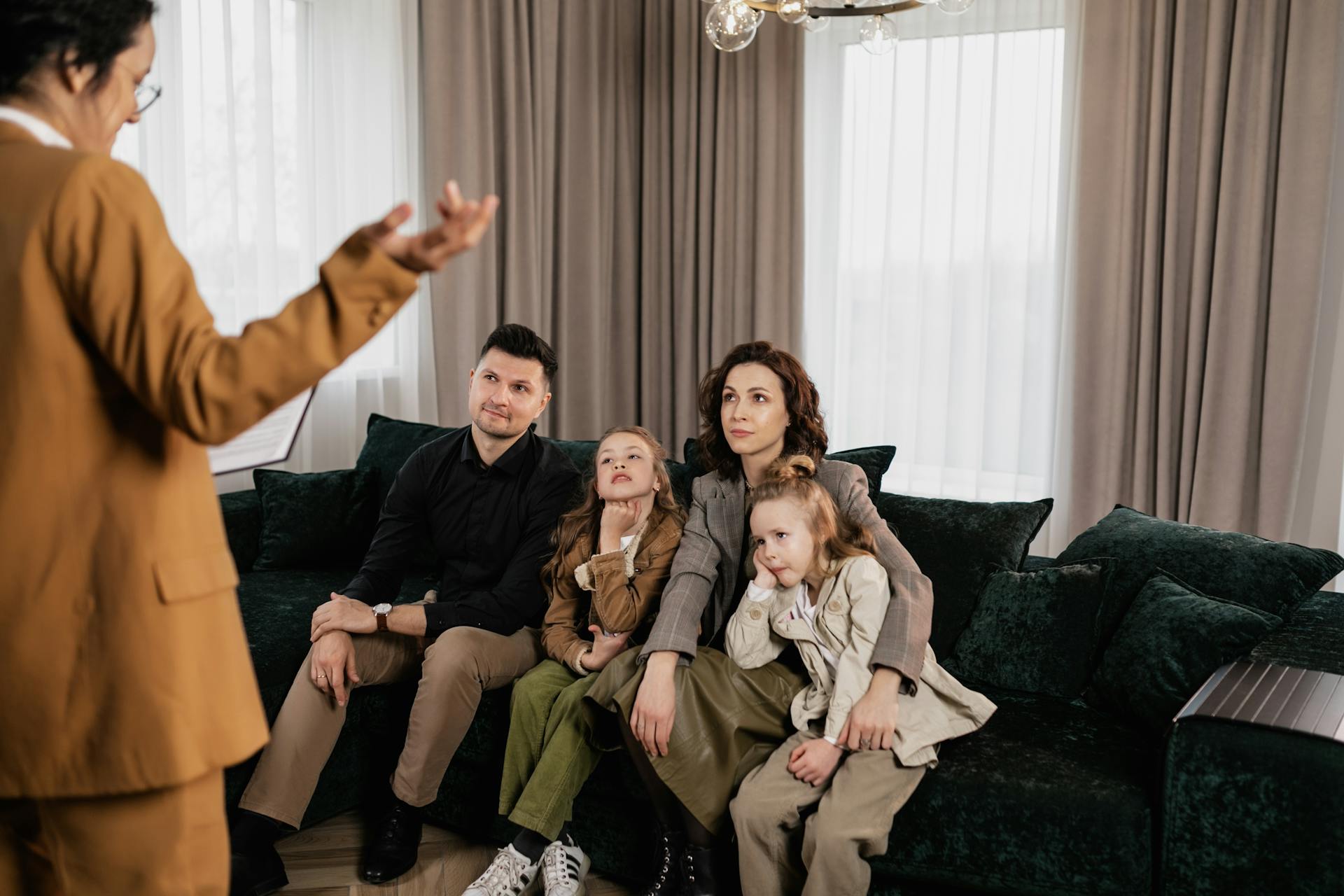 A family meeting with a real estate agent in a cozy living room, discussing home buying options.