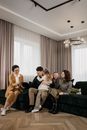 3 Women and 2 Men Sitting on Black Sofa
