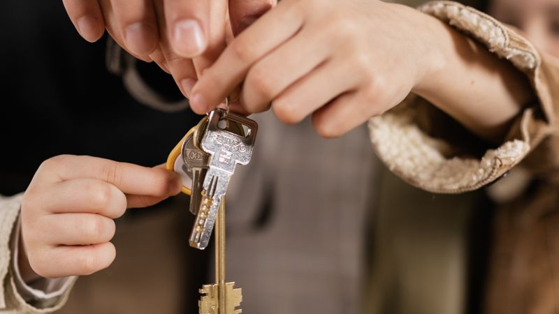 Close-up of a family holding house keys, symbolizing home ownership.