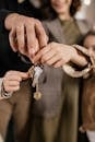 People Holding a Set of Keys Together