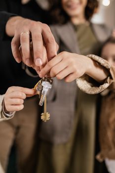 Close-up of a family holding house keys, symbolizing home ownership.