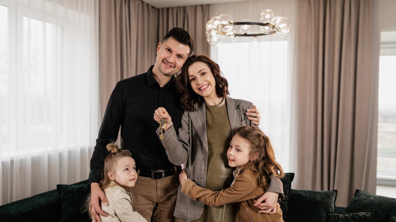 Family planning finances after buying a first home Family holding new home keys after completing a first home purchase