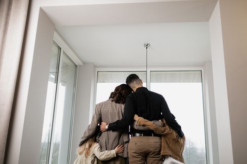 Free A family embraces warmly by a window, symbolizing love and togetherness indoors. Stock Photo
