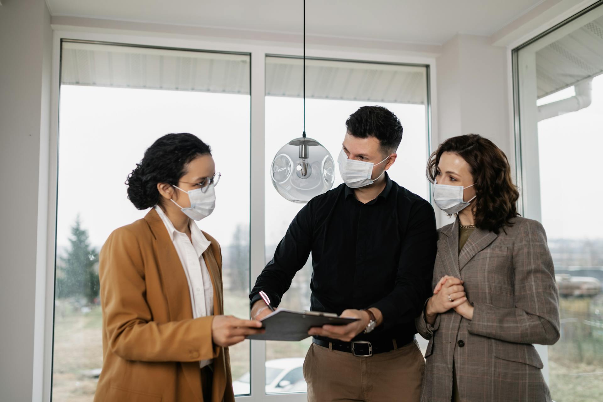 A Couple Signing a Contract with a Realtor