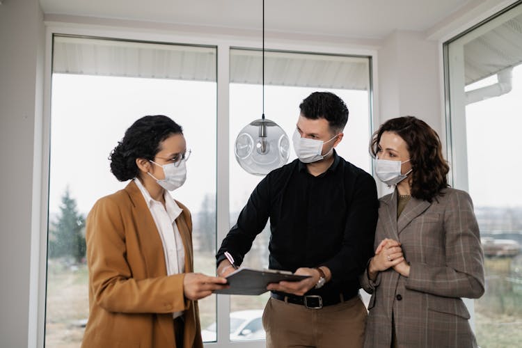 
A Couple Signing A Contract With A Realtor