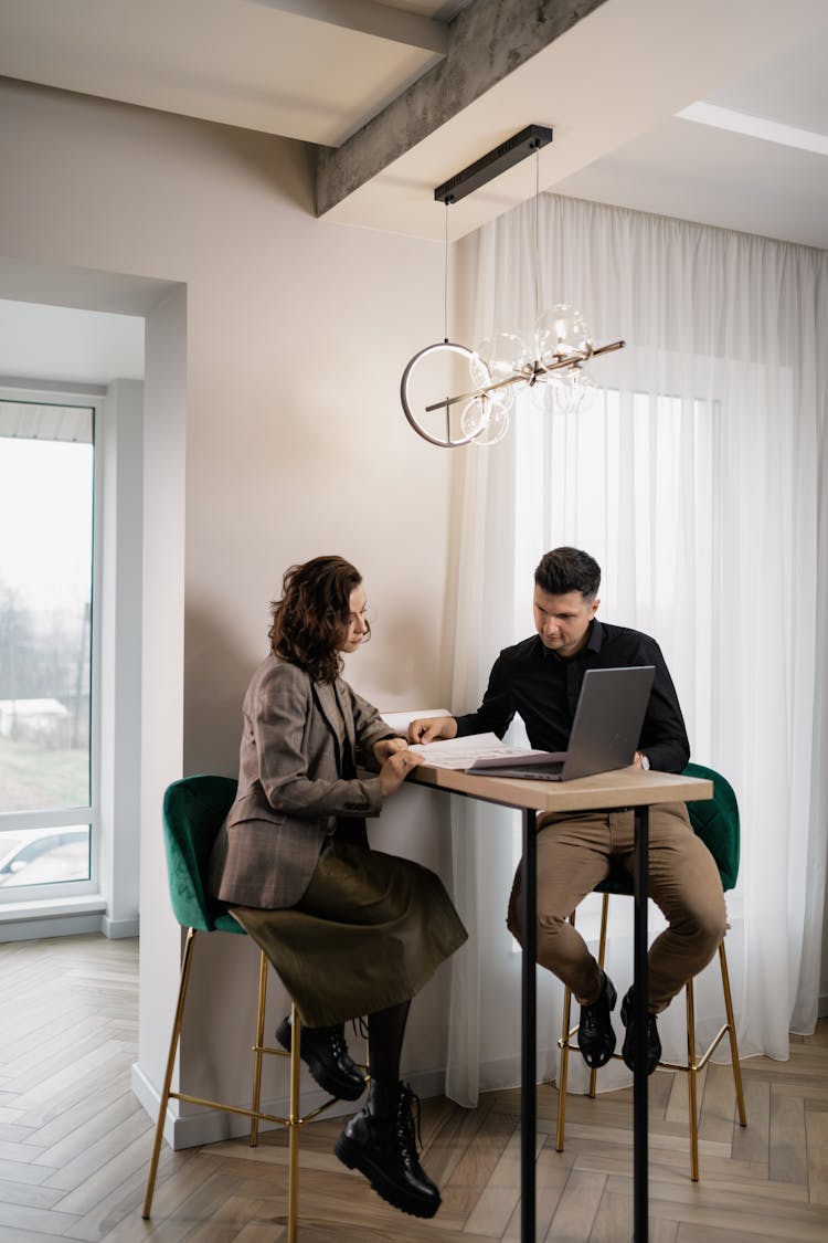 
A Couple Looking At Documents While Sitting