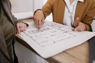 Person in Brown Blazer Holding White Printer Paper