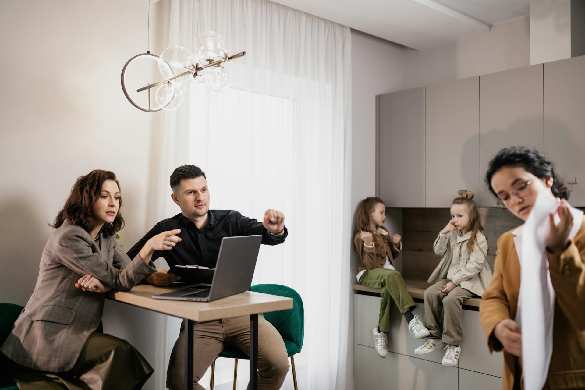 Family discussing real estate purchase inside home with agent and children present.