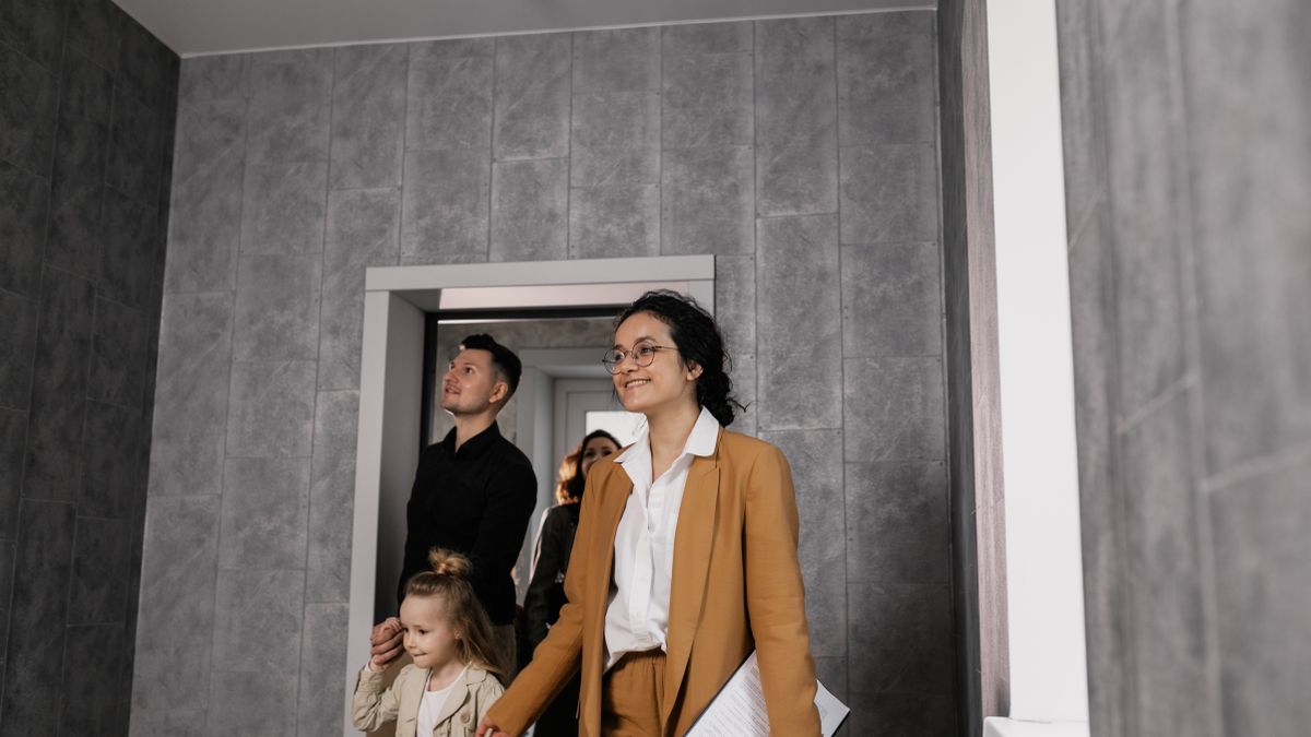 A realtor showing a family their prospective new home in a modern apartment.