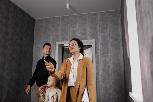 A family explores a modern home interior with a professional realtor guiding them.