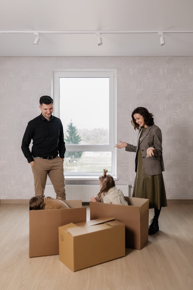 Smiling Parents Over Girls Hiding In Boxes