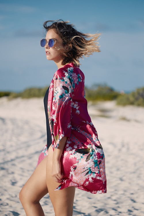 Trendy model in sunglasses on sandy beach