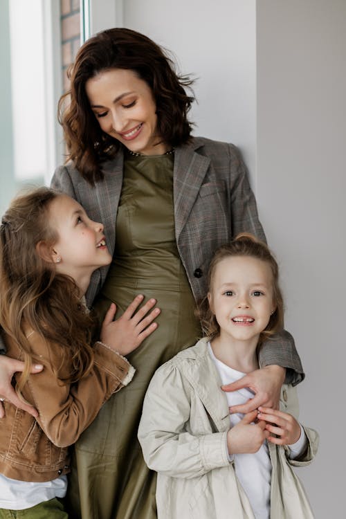 A Happy Woman Holding her Daughters Close