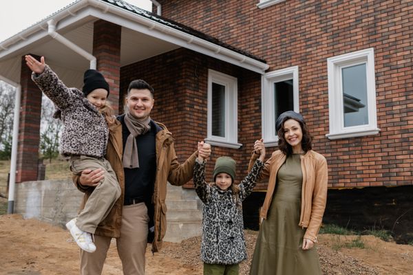 Happy family in front of their home
