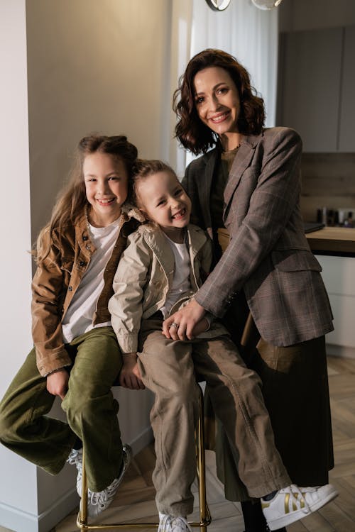 Free Woman in Gray Blazer Standing beside a Girl in Brown Jacket and Brown Pants Stock Photo