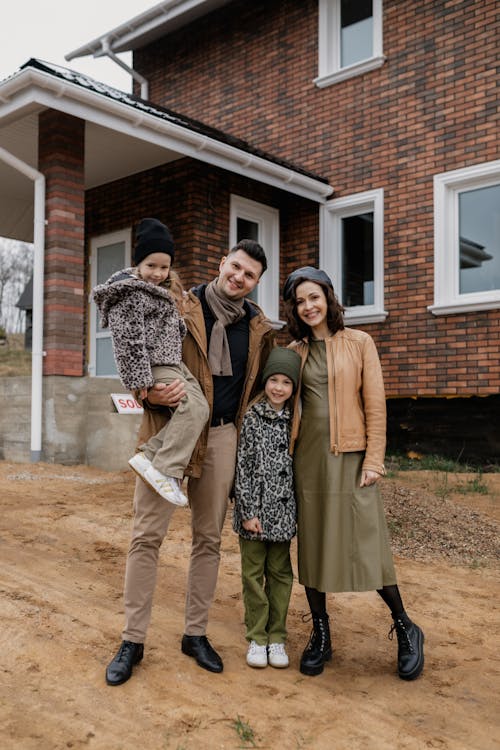 Free Family Standing Near a Break House
 Stock Photo