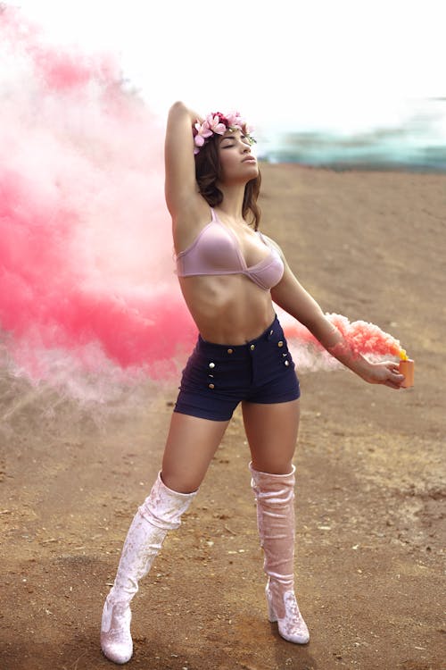 A Woman in a Brassiere Holding a Smoke Bomb