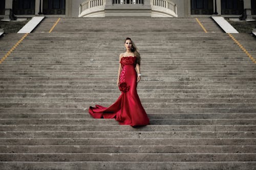 Woman in Red Evening Dress Standing on Stairs