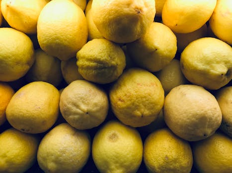 A vibrant close-up of fresh yellow lemons, showcasing their textured skin and bright color.