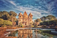 日落时分，一座灯火通明的古老印度寺庙倒映在宁静的池塘中