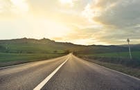 日落时分，意大利托斯卡纳空旷的道路上，捕捉到了宁静的乡村风光和连绵起伏的山丘