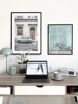 Elegant workspace featuring laptop and framed art in modern Copenhagen interior.