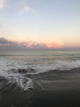 Tranquil ocean waves during a beautiful Bali sunset captured from the shore.