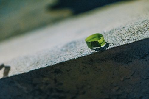 Free Close-up of a green leaf folded into a ring on textured concrete. Stock Photo