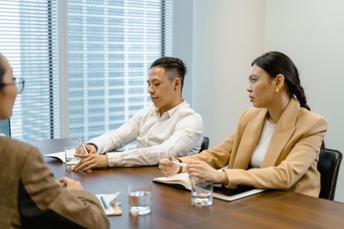 Free Business professionals in a meeting room discussing and taking notes. Ideal for teamwork and corporate themes. Stock Photo