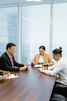 Business professionals having a meeting in a contemporary office, focused on teamwork.